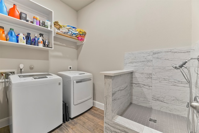 clothes washing area featuring hardwood / wood-style flooring and washing machine and clothes dryer