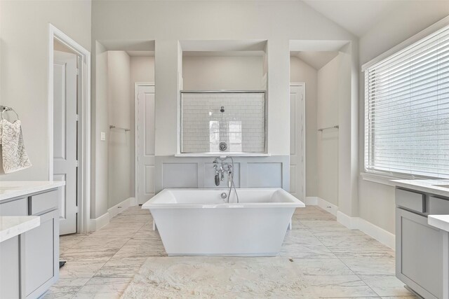 bathroom with vanity, tile patterned floors, and a tub to relax in