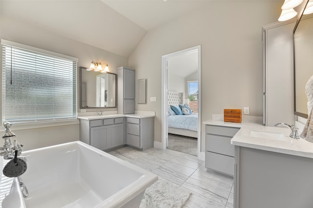 bathroom with tile patterned flooring, a bathtub, vaulted ceiling, and double sink vanity