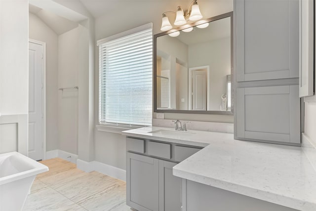 bathroom with a chandelier, vanity, tile patterned floors, a tub to relax in, and vaulted ceiling