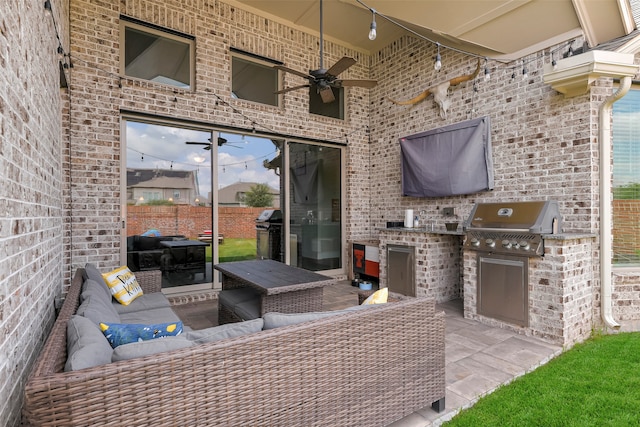 view of patio with grilling area, ceiling fan, and an outdoor kitchen