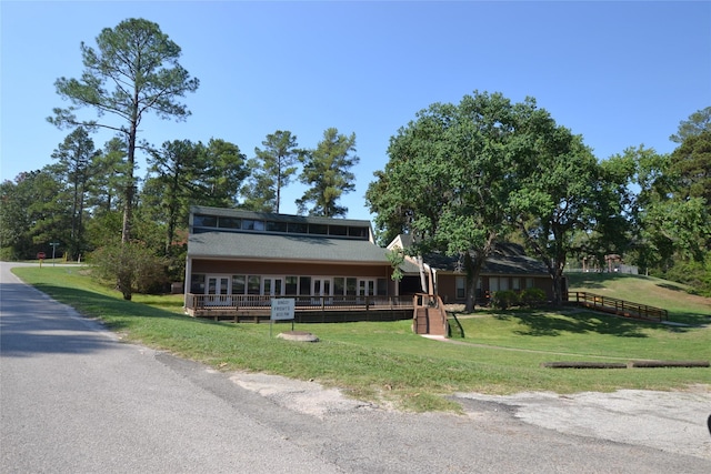 view of front of house featuring a wooden deck and a front yard