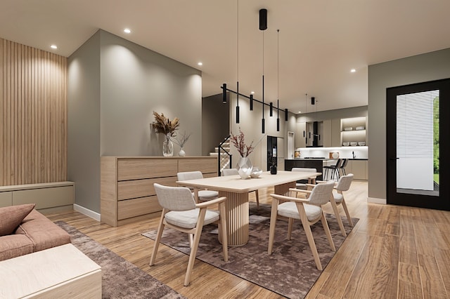 dining area featuring a barn door and light hardwood / wood-style flooring