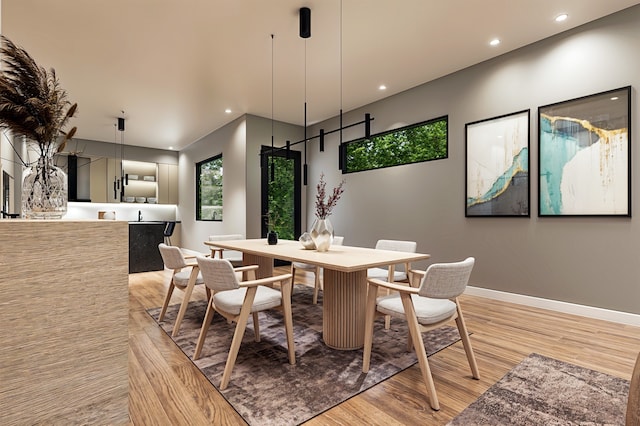 dining area featuring a barn door and light hardwood / wood-style flooring