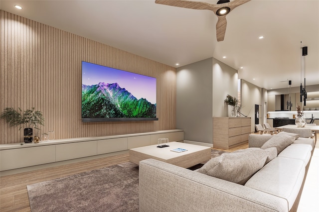 cinema room with ceiling fan and hardwood / wood-style floors