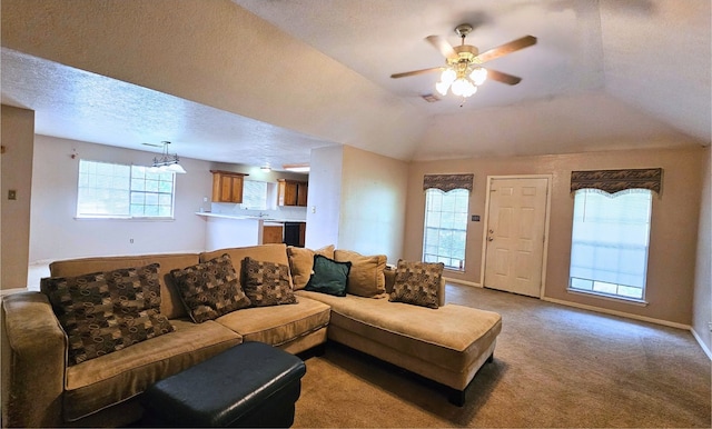 living room featuring light carpet, ceiling fan, a raised ceiling, and a textured ceiling