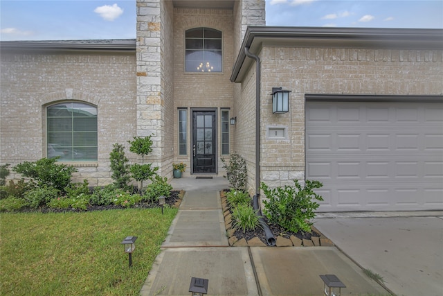 property entrance with a garage and a yard