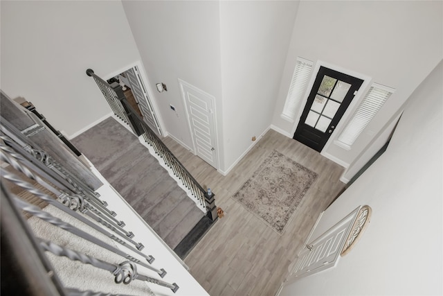 foyer with wood-type flooring and a towering ceiling