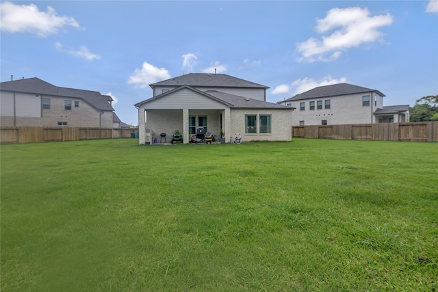 rear view of house featuring a yard and a patio area