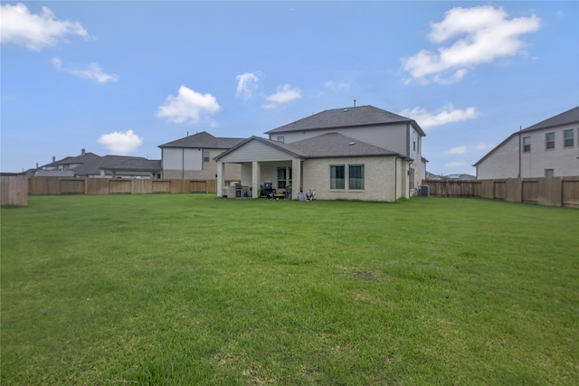 back of house featuring a patio area and a lawn