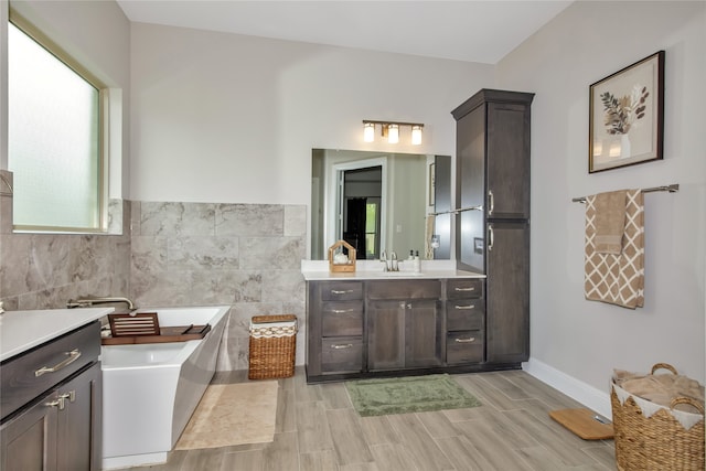 bathroom with tile walls, vanity, and a bathtub