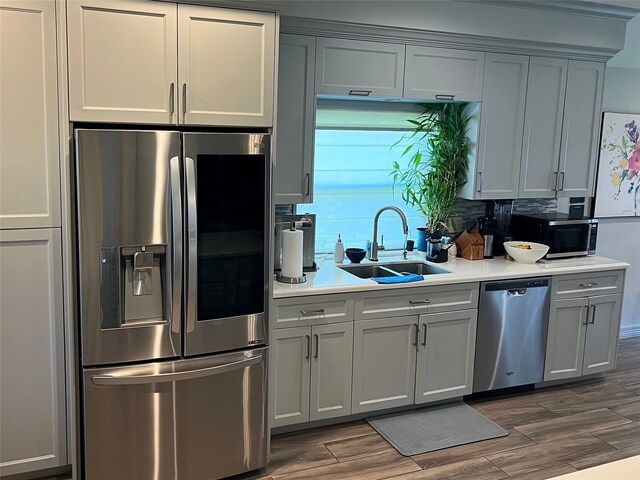 kitchen featuring gray cabinetry, stainless steel appliances, sink, and dark hardwood / wood-style flooring