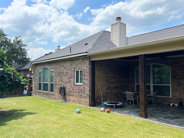 back of house featuring a lawn and a patio area