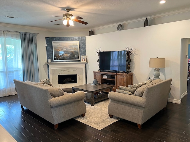 living room with ceiling fan, a fireplace, dark hardwood / wood-style floors, and ornamental molding