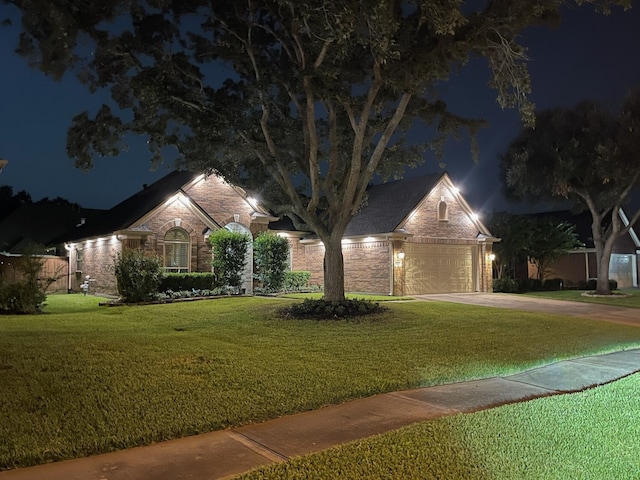 ranch-style home featuring a lawn and a garage