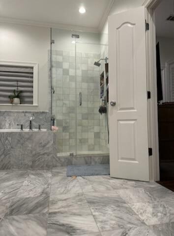 bathroom with ornamental molding and walk in shower