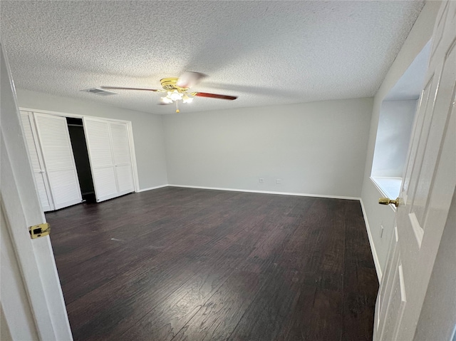 interior space featuring a textured ceiling, ceiling fan, and dark hardwood / wood-style flooring