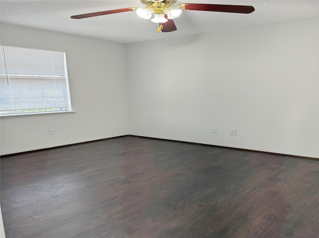 empty room featuring ceiling fan, dark hardwood / wood-style floors, and a textured ceiling