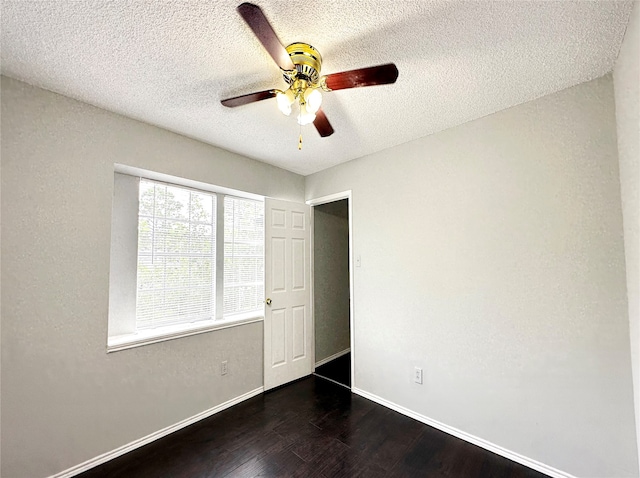 interior space with ceiling fan, a textured ceiling, and dark wood-type flooring