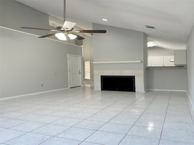 unfurnished living room with lofted ceiling, ceiling fan, a tile fireplace, and light tile patterned flooring