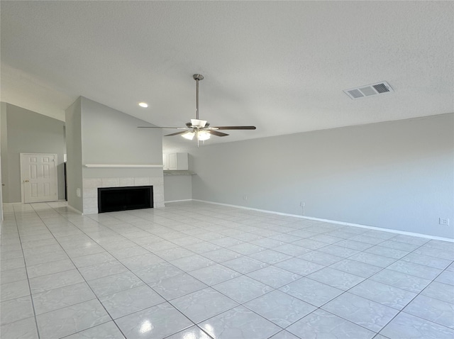 unfurnished living room with vaulted ceiling, a tile fireplace, light tile patterned floors, a textured ceiling, and ceiling fan