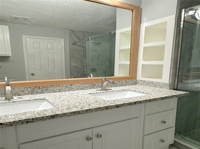 bathroom with walk in shower, a textured ceiling, and vanity