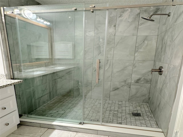 bathroom featuring vanity, tile patterned floors, and a shower with shower door