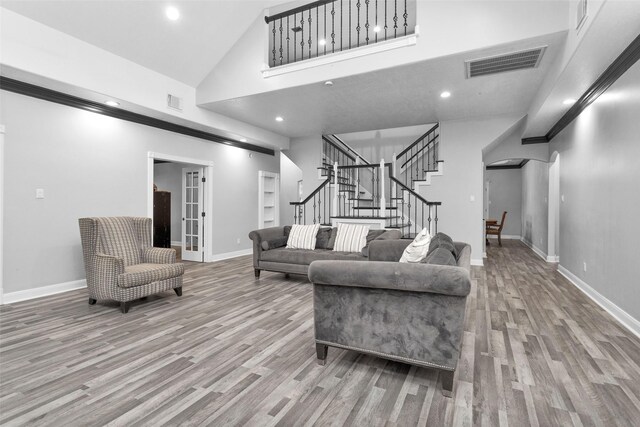 living room with wood-type flooring and high vaulted ceiling