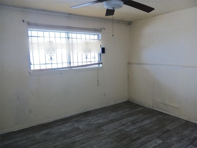 spare room with a textured ceiling, a healthy amount of sunlight, and dark hardwood / wood-style floors