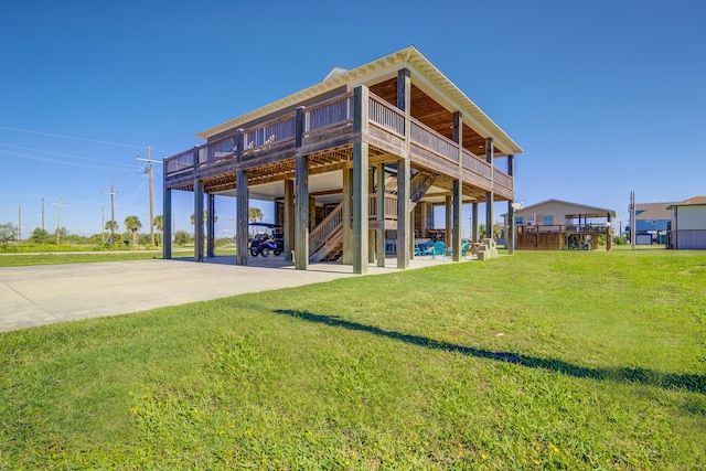 rear view of property featuring a wooden deck, a patio area, and a yard