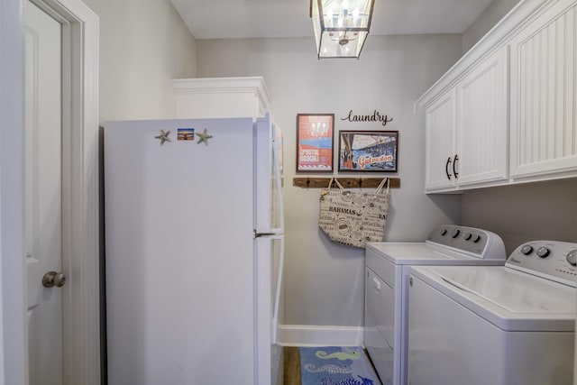 washroom with washing machine and dryer and cabinets