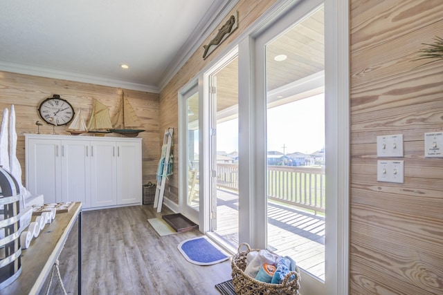 doorway with light wood-type flooring, ornamental molding, and recessed lighting