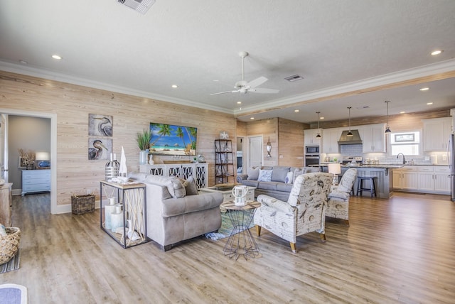 living area with visible vents and ornamental molding