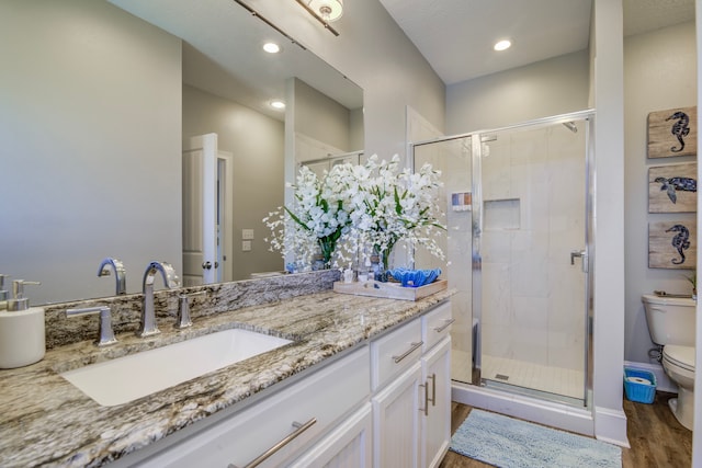 bathroom featuring vanity, toilet, hardwood / wood-style flooring, and walk in shower