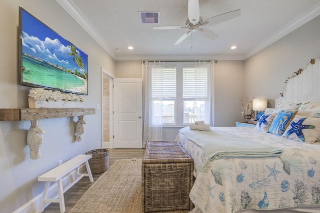 bedroom with baseboards, visible vents, crown molding, and wood finished floors