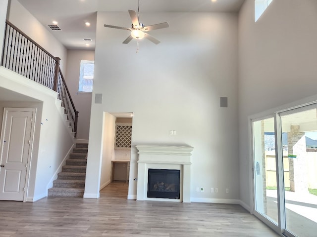 unfurnished living room featuring plenty of natural light and a towering ceiling