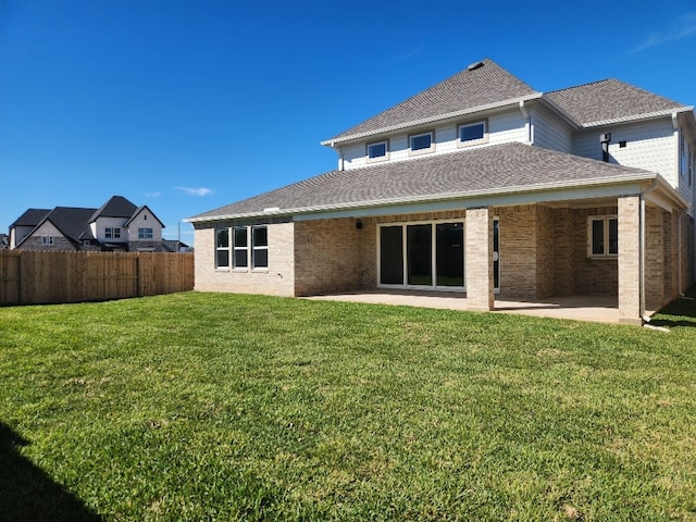 rear view of house featuring a yard and a patio