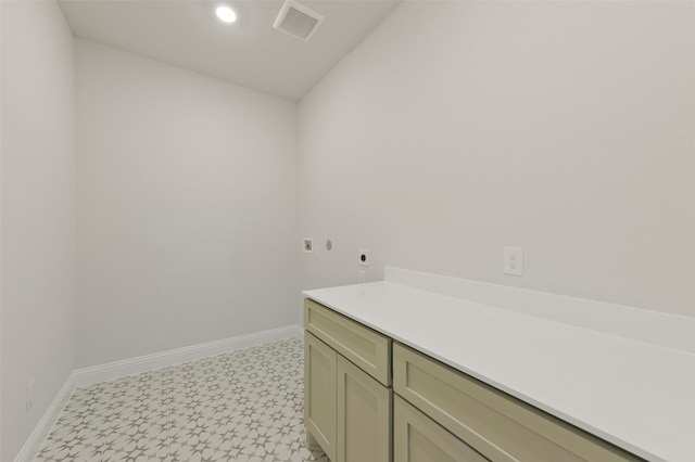 clothes washing area featuring cabinets and hookup for an electric dryer