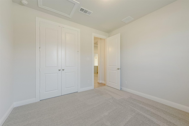 unfurnished bedroom featuring light carpet and a closet