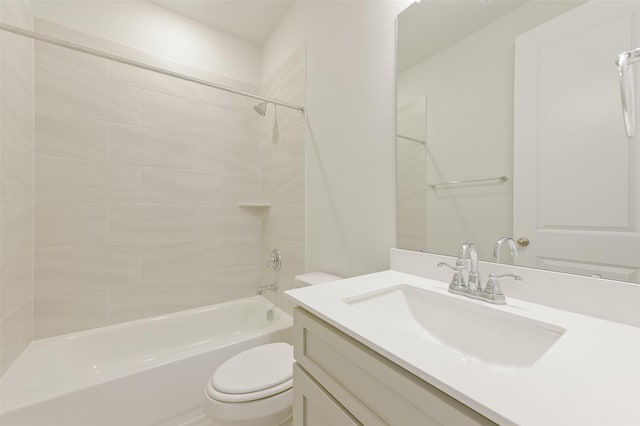 full bathroom with vanity, tiled shower / bath, and toilet