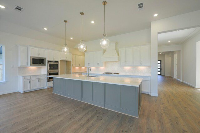 9931 Hunters Run Dr, Missouri City, TX 77459 - kitchen featuring premium range hood, white cabinetry, appliances with stainless steel finishes, and sink
