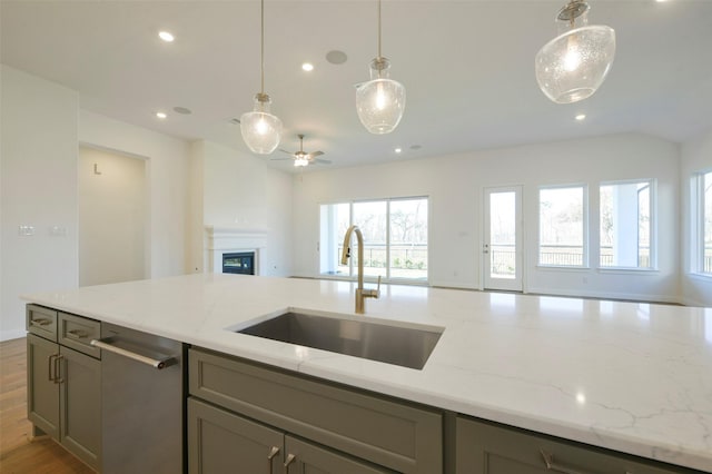 9931 Hunters Run Dr, Missouri City, TX 77459 - kitchen with sink, gray cabinetry, light stone counters, and light wood-type flooring