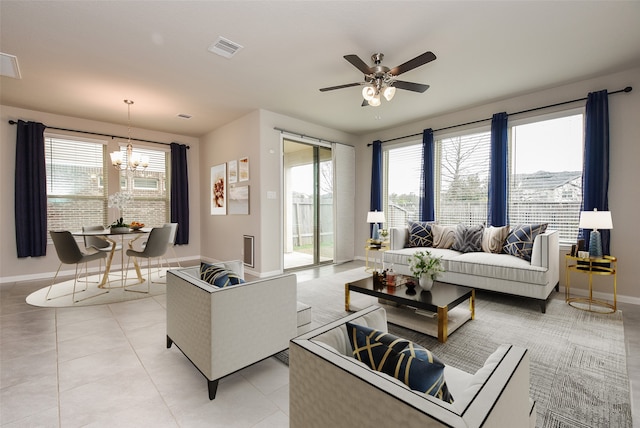 tiled living room with ceiling fan with notable chandelier