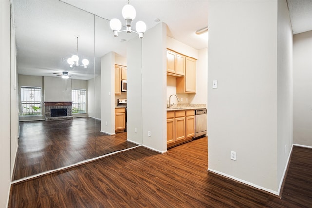 kitchen featuring ceiling fan with notable chandelier, dark hardwood / wood-style flooring, appliances with stainless steel finishes, and sink