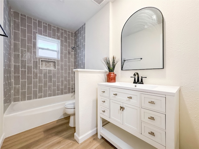 full bathroom with vanity, toilet, tiled shower / bath combo, and hardwood / wood-style floors