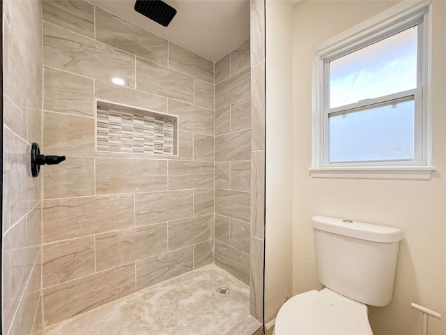 bathroom with tiled shower and toilet