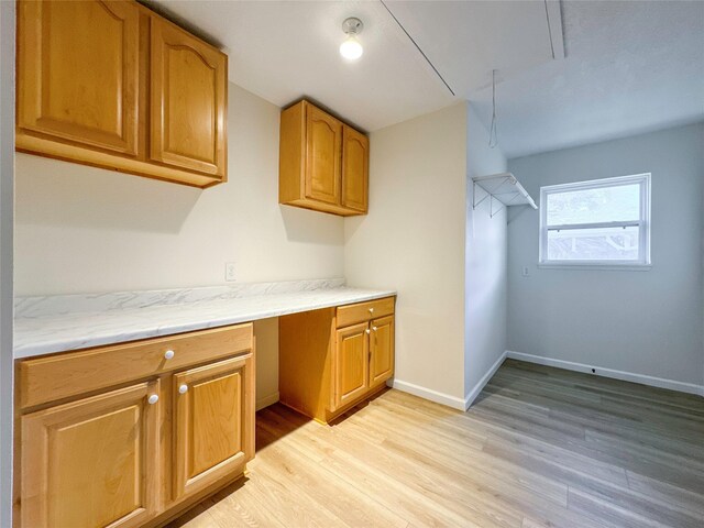 kitchen with built in desk and light hardwood / wood-style flooring