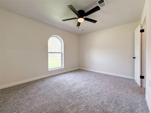 carpeted empty room with a textured ceiling and ceiling fan