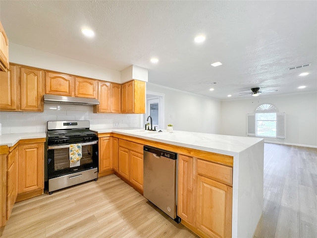 kitchen featuring light hardwood / wood-style flooring, ceiling fan, appliances with stainless steel finishes, and kitchen peninsula