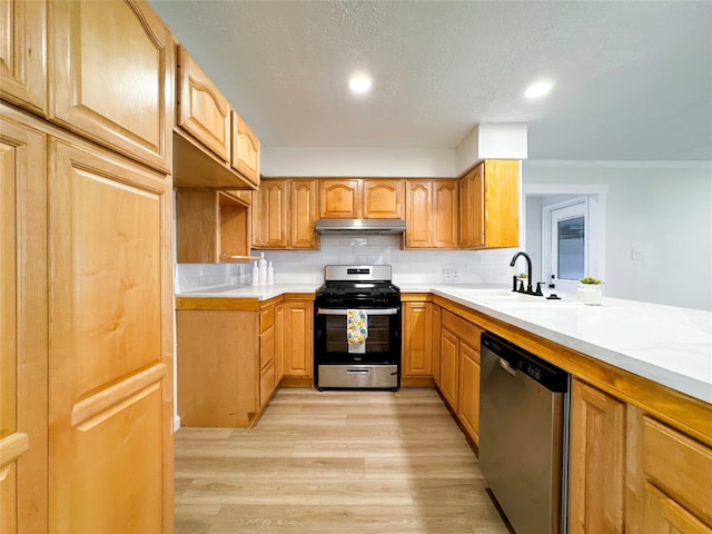 kitchen with a textured ceiling, appliances with stainless steel finishes, tasteful backsplash, sink, and light wood-type flooring